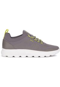 Zapatillas grises con parte superior de punto, acentos verdes y una suela blanca acolchada. Presentan una tira de agarre en el talón y detalles texturizados.