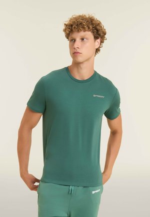 T-shirt verde a maniche corte in tessuto morbido e liscio, con collo rotondo e un piccolo logo discreto sul lato sinistro del petto.
