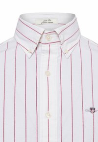 Weißes Oxford-Hemd mit roten vertikalen Streifen, knöpfbarem Kragen und schmaler Passform. Mit Logo auf der Brust und Kunststoffknöpfen.