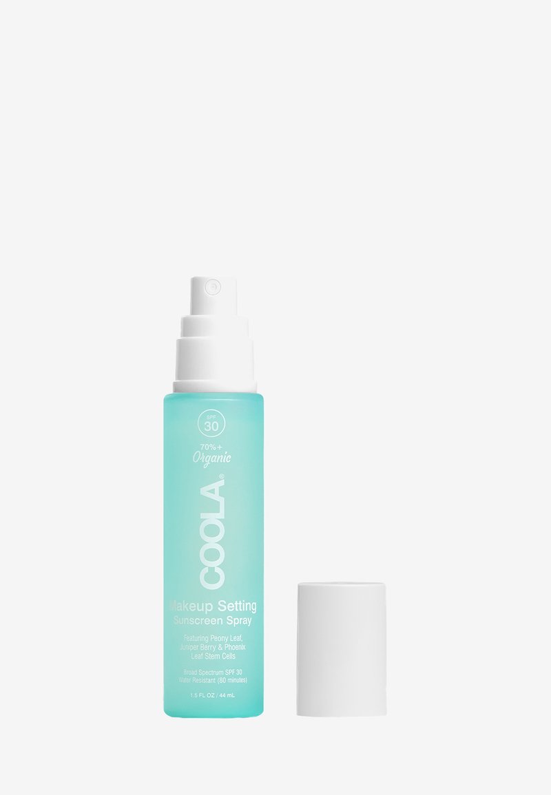 Aqua-Sprühflasche mit einem weißen Pumpenkopf. Das Etikett zeigt "COOLA Makeup Setting Sunscreen Spray", SPF 30 und organische Inhaltsstoffe. 1,5 fl oz.