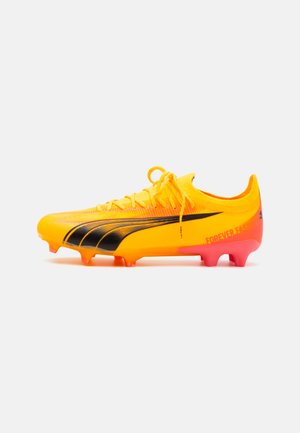 Crampon de football jaune avec des rayures noires et un graphique "FOREVER.FASTER", présentant un dessus texturé et des accents roses sur la semelle.