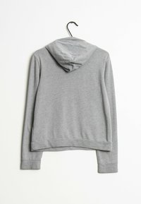 Grå sweatshirt med huva, lång ärm och ribbade manschetter. Slät textur och avslappnad design, med cropped längd och minimal detaljering.