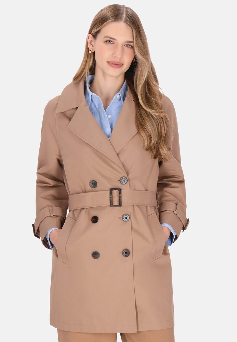 Palton bej cu design cu două rânduri de nasturi, rever mare, curea în talie și manșete cu nasturi. Dispune de buzunare laterale.