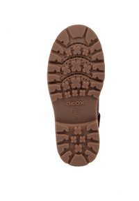 Suela de goma marrón con patrones de tracción profundos, que presentan diseños circulares y florales. Logo "GEOX" y detalles de patente visibles.