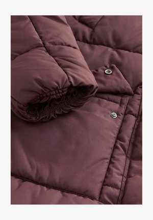 Sezione di giacca a vento borgogna con tessuto strutturato, polsini elasticizzati e bottoni a pressione argentati, caratterizzata da un motivo di cuciture a trapunta.