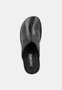 Black leather slip-on shoe with a rounded toe, stitched detailing, cushioned insole, and minimalistic design. Labeled inside.