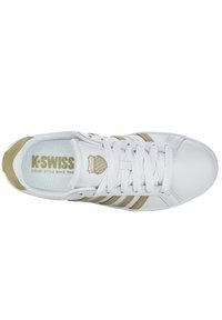 White K-Swiss sneaker with gold accents, mesh upper, flat laces, and padded collar. Features logo on tongue and three stripes on sides.