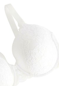 Hvid blonde-bh med formet skål, glat stof, justerbare stropper og delikat blomstermønster på blondeoverlaget.