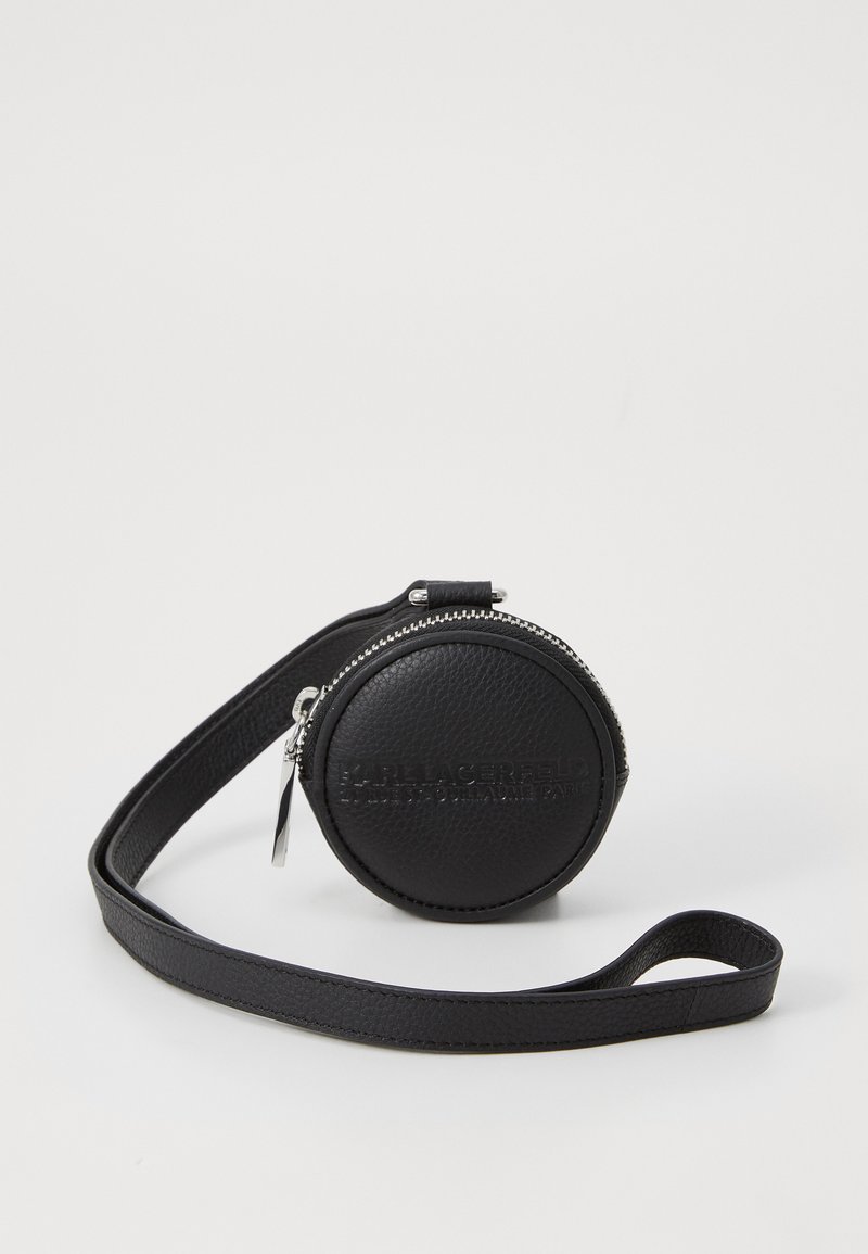 Schwarze runde Ledertasche mit strukturiertem Oberflächen, silbernem Reißverschluss, Marken-Details und abnehmbarem Tragegurt. Kompaktes Design für einfachen Transport.