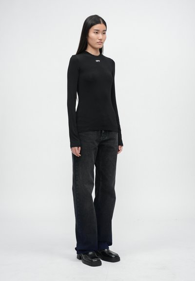 Top negru cu mâneci lungi, guler rotund și logo-ul alb "OFF", asortat cu blugi negri cu talie înaltă și pantofi negri. Design simplu.