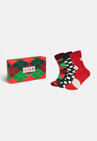 Calze argyle rosse e verdi con pois neri e bianchi, confezionate in una scatola coordinata con il marchio 'Happy Socks'.