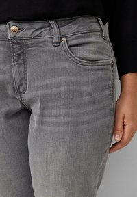 Jeans en denim gris au toucher lisse, dotés d'un design classique à cinq poches et d'un léger dégradé. Matériel en ton doré inclus.