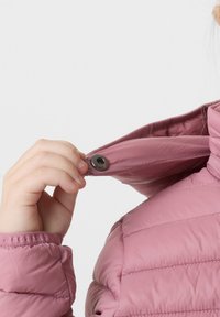 Giacca puffer rosa chiaro con texture trapuntata; mano che tiene il collo con bottoni. Presenta una chiusura a pressione e una finitura in tessuto morbido.