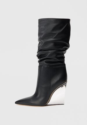 Bottines en cuir noir avec un design froncé, un bout pointu et un talon compensé métallique haut. Présente un logo sur le côté.