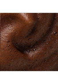 Close-up af rig, luftig mørk chokolademousse med små bobler og en glat, cremet tekstur.