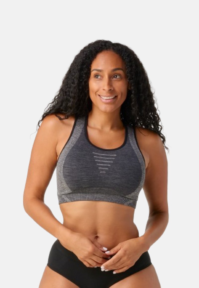 Sujetador deportivo negro y gris con un diseño texturizado y transpirable, con tirantes ajustables y costuras reforzadas para mayor sujeción.