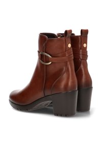 Botas de tobillo de cuero marrón con una textura suave, que presentan un acento de correa y hebilla, punta redonda y tacón cuadrado.