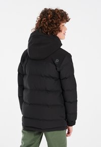 Doudoune noire avec une capuche, dotée d'un design matelassé, de poignets élastiques et d'un logo sur l'épaule. Silhouette ajustée.