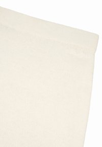 Kermaankeltainen kangas, jossa on pehmeä koostumus, hienovarainen vinokuvio ja reunassa kirjailtu "Oh Love" -yksityiskohta.