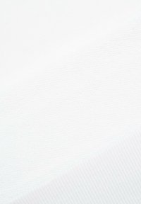 Biała tkanina o teksturze z ukośnymi liniami i prążkowanym brzegiem w prawym dolnym rogu.