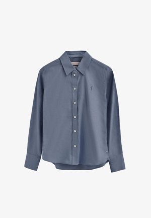 Camicia azzurro chiaro a maniche lunghe con colletto appuntito, chiusura frontale con bottoni e logo ricamato sul petto a sinistra. Tessuto dalla texture liscia.