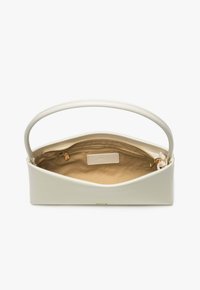 Small off-white handbag with a curved handle, open top showing beige fabric interior with a zippered pocket and gold zipper pull.