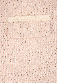 Rosa Tweed-Stoff mit metallischen Fadenakzenten und Pailletten. Verfügt über eine kleine Tasche mit einer strukturierten cremefarbenen Detail.