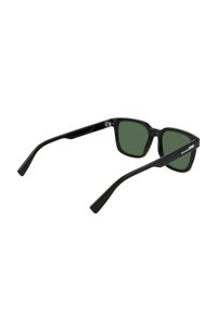 Ochelari de soare din plastic negru, cu rame pătrate și lentile verzi. Au brațe elegante, ușor curbate și un branding minim pe lateral.