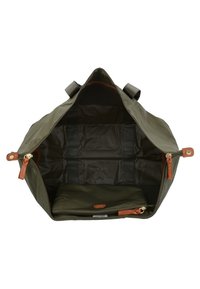 Borsa a duffle realizzata in resistente tessuto verde oliva con un ampio interno, dotata di zip color sabbia e scomparti organizzativi.