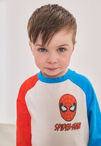 Maglietta in cotone con maniche raglan rosse e blu, con grafica di Spider-Man sul davanti e collo rotondo.