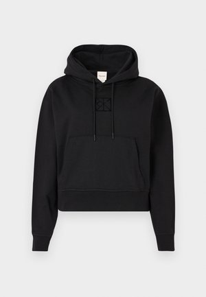 Svart cropped hettegenser laget av mykt stoff. Den har en frontlomme, justerbar hette og en subtil brodert logo på brystet.