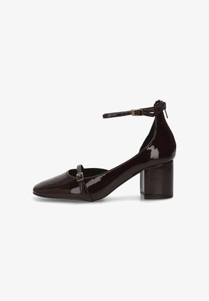 Zapato de tacón bloque de color marrón oscuro brillante con punta afilada, tira en el tobillo con hebilla y tira frontal de estilo Mary Jane bajo.