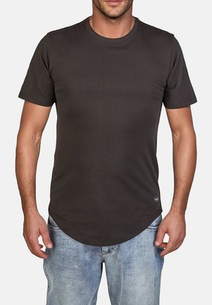 Camiseta de manga corta gris oscuro hecha de una tela lisa, con un escote redondo y un diseño de dobladillo curvo, combinada con unos vaqueros azules desgastados.