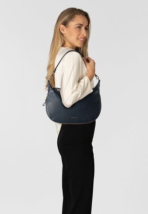 Borsa a tracolla in pelle blu navy con finitura texturizzata, caratterizzata da una forma arrotondata e una tracolla con dettagli a catena. Dettaglio logo dorato sulla parte anteriore.