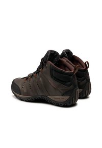 Un par de botas de senderismo impermeables en marrón y negro, con suelas Techlite, cuellos acolchados y tiradores, mostradas desde un ángulo posterior.