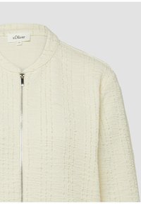 Crèmekleurig jasje met zilveren rits aan de voorkant en ronde hals, maat 36 van het merk s.Oliver.