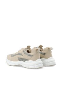 Beige sportssko med mesh-paneler, rund tå, hvid chunky sål og grib på hælen for nem påføring. Teksturerede detaljer i hele skoen.