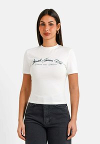 Hvid bomulds T-shirt med korte ærmer, smal pasform og rund halsudskæring. Har trykt tekst i mørkeblå, centreret på brystet.