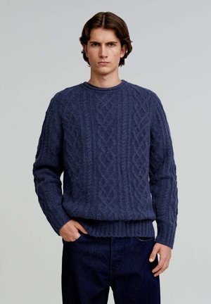 Navy blauwe gebreide trui met kabelpatroon, ronde hals en geribbelde onderkant. Gemaakt van een gestructureerd materiaal, met lange mouwen en een relaxed fit.
