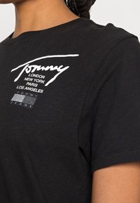 Svart bomullströja med rund halsringning. Har vit tryckt logotext och stadnamn på bröstet. Korta ärmar, standardpassform.