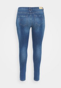 Dark blue skinny jeans made of denim, featuring a mid-rise waistband, five pockets, and a smooth, textured finish.
