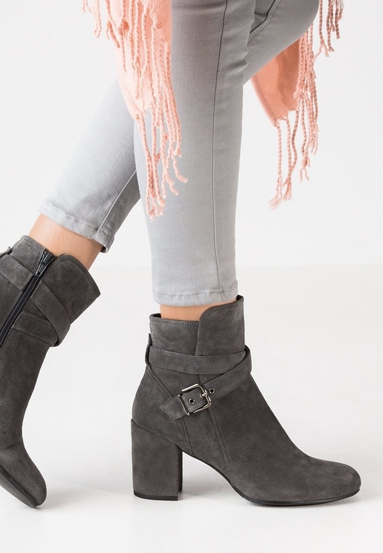 Graue Wildleder-Ankle Boots mit runder Zehenpartie und Blockabsatz. Mit einem diagonalen Riemen mit einer Metallschnalle und einem seitlichen Reißverschluss.