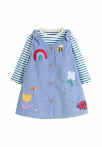 Robe salopette en velours côtelé bleu avec des broderies d'arc-en-ciel, d'abeille, de fleurs, de papillon et de coccinelle sur une chemise à manches longues rayée blanche et bleue.