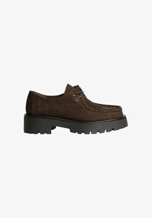 Zapato de ante marrón con punta redondeada, detalles cosidos y suela de goma negra con un patrón de tacos. Diseño de cordones con dos ojetes.