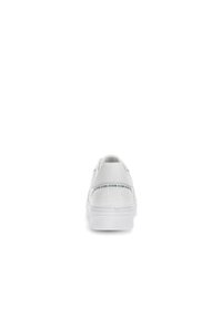 Witte sneaker met gestructureerd patroon, ronde neus en gevoerde zool. Logo-band op de hiel en glad leren materiaal. Eenvoudig, low-profile ontwerp.