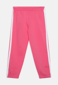 Fleece sweatpants i lys pink med hvide sidelister, elastisk talje og tapered ben. Blød tekstur og en afslappet pasform.