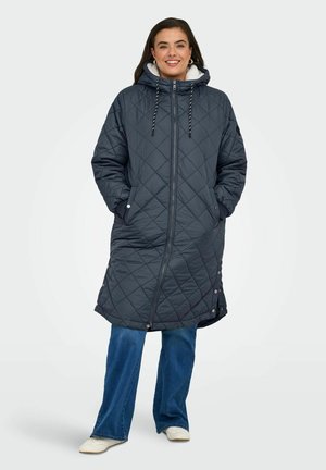 Gequilted donkergrijs lang jasje met een capuchon, voorzien van een ritssluiting aan de voorkant, aantrekkoordjes en zijzakken. Gladde textuur met knoopaccenten.