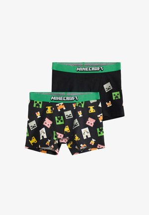 Kaksi paria poikien Minecraft-boxer shortsit. Toiset ovat mustat vihreällä vyötärönauhalla, kun taas toiset ovat värikkäällä pikselöidyllä hahmotulosteella.