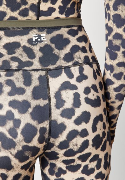 Leggings z leopardjim vzorcem v bež in črni barvi s prilegajočim dizajnom. Imajo kontrastni pas v olivno zeleni barvi in vidne šive.