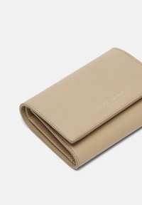 Portafoglio in pelle beige con una texture liscia, caratterizzato da un logo impreziosito in oro, forma rettangolare e design a tre pieghe.